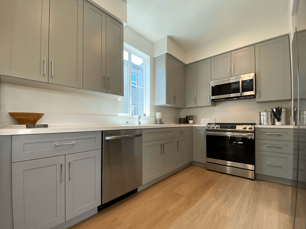 a kitchen with gray cabinets and a window