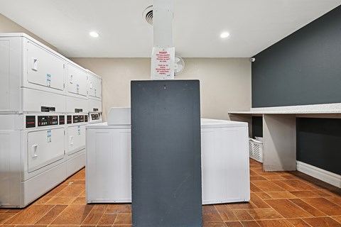 A kitchen with a black counter and white appliances.