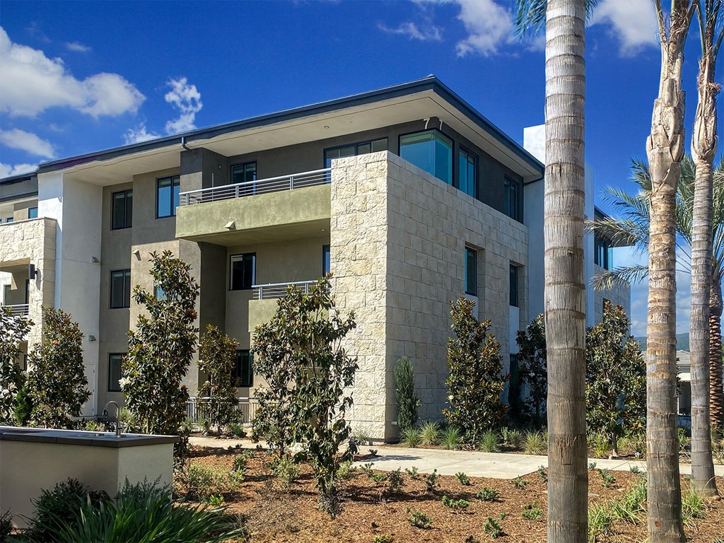 a view of a house with palm trees in front of it at The Max on Jefferson Apartments, Murrieta, California