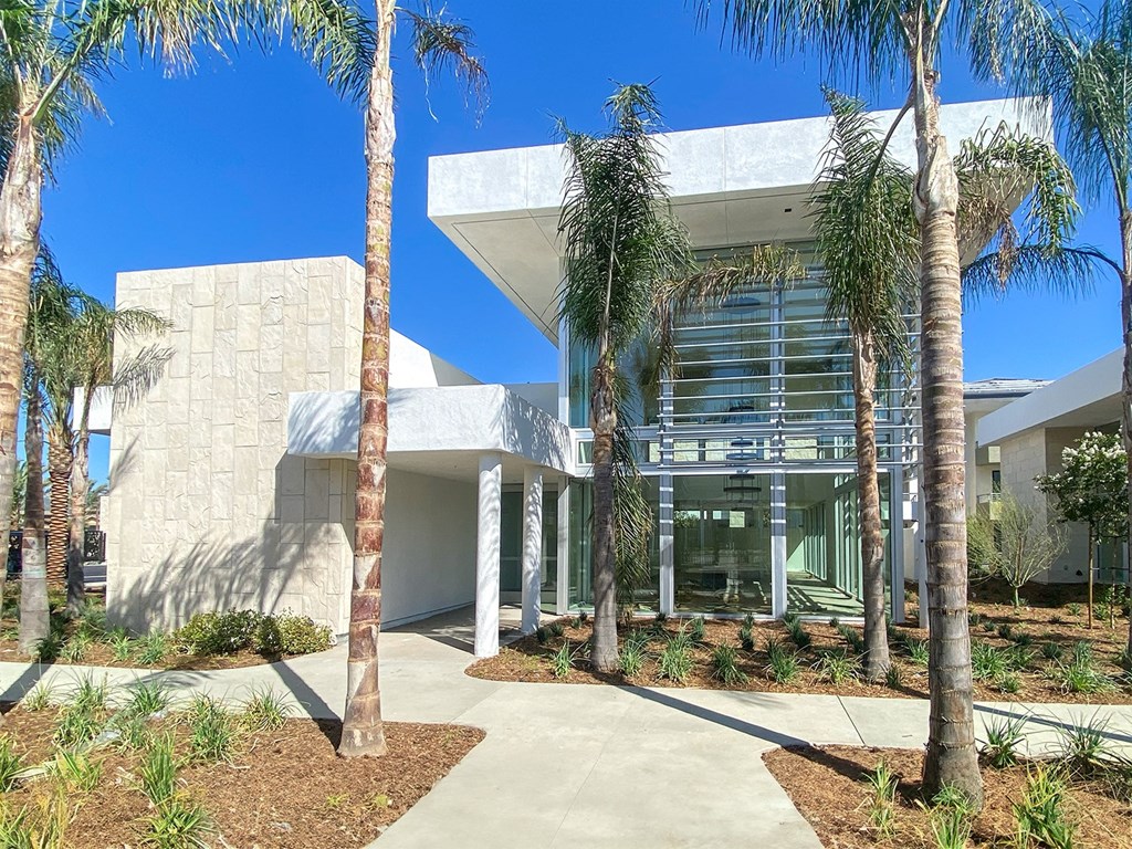 a building with palm trees in front of it at The Max on Jefferson Apartments, Murrieta, CA
