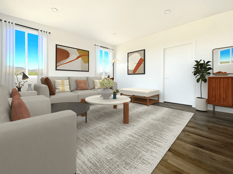 A living room with a grey couch, a coffee table, and a large painting on the wall.