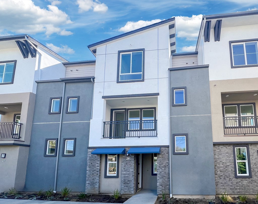 an apartment building with a sidewalk in front of it at The Willow Townhomes, Ontario, California 91762