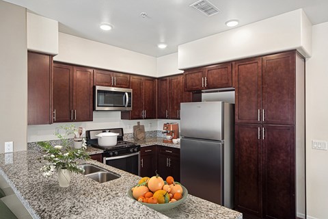 A kitchen with a refrigerator, microwave, and stove.