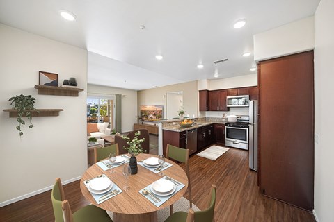 A modern kitchen with a dining table set for two.