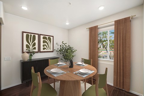 A dining room with a table set for two and a potted plant on the table.