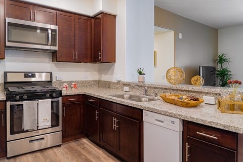 A kitchen with brown cabinets and a stainless steel oven.