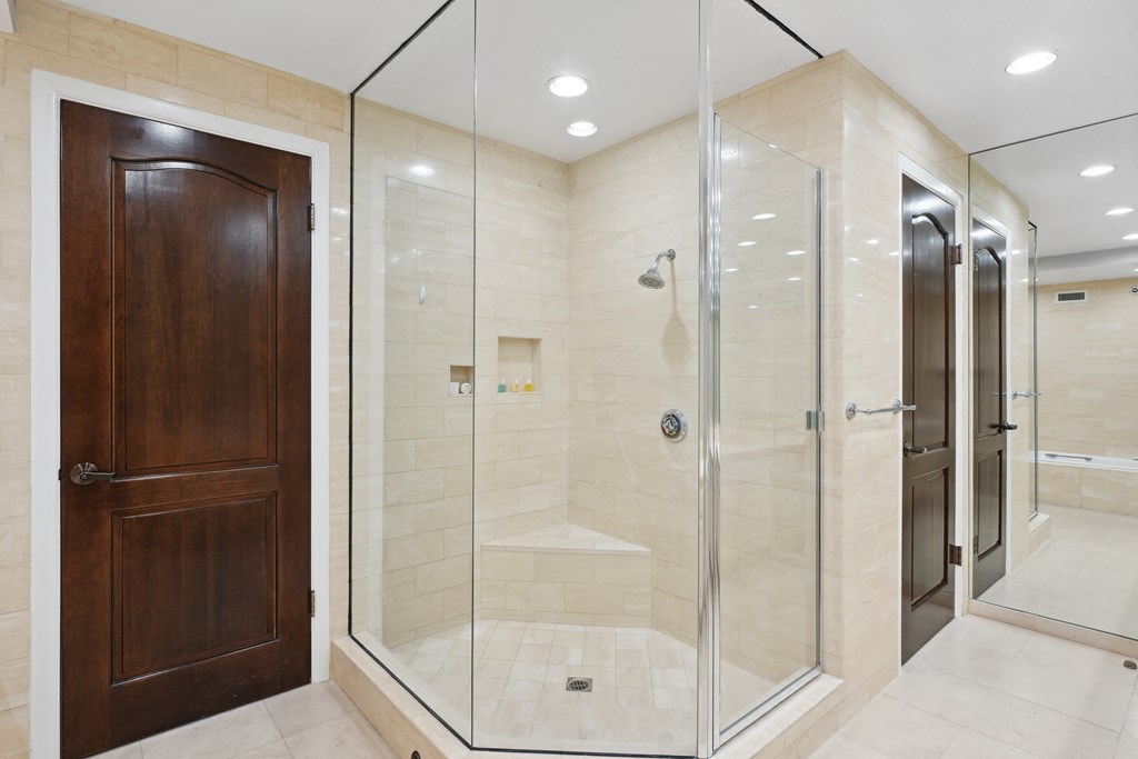 a bathroom with a shower and a wooden door