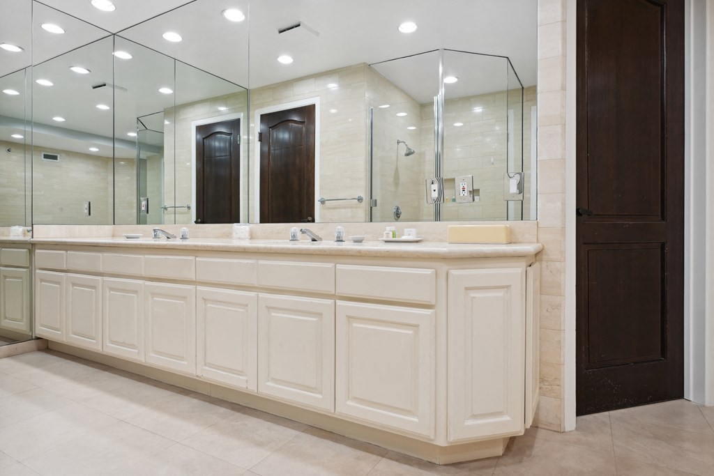 the master bathroom has a large vanity with two sinks and a large mirror