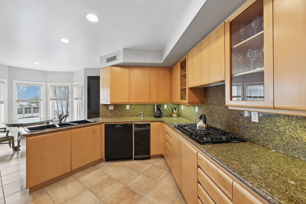 the kitchen has granite counter tops and wooden cabinets