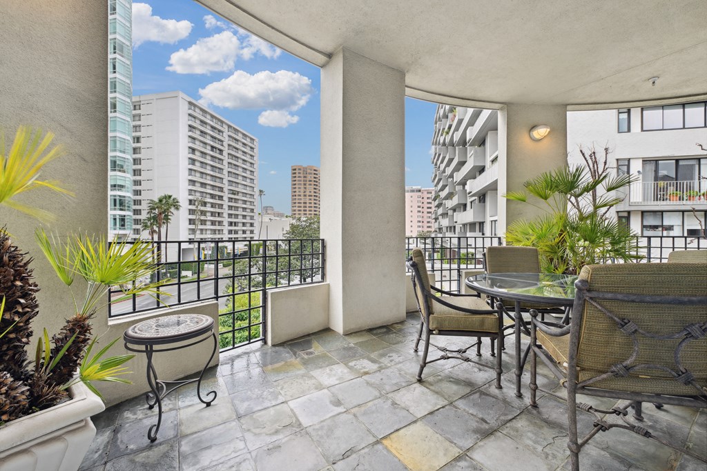 a balcony with a table and chairs and a view of the city