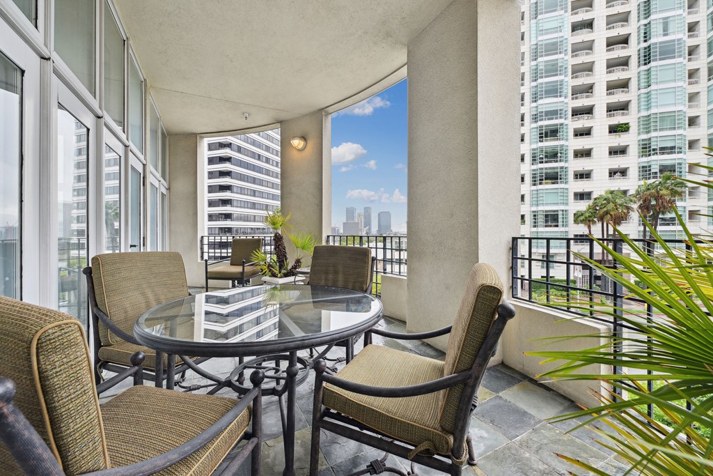 a balcony with a table and chairs and a view of skyscrapers