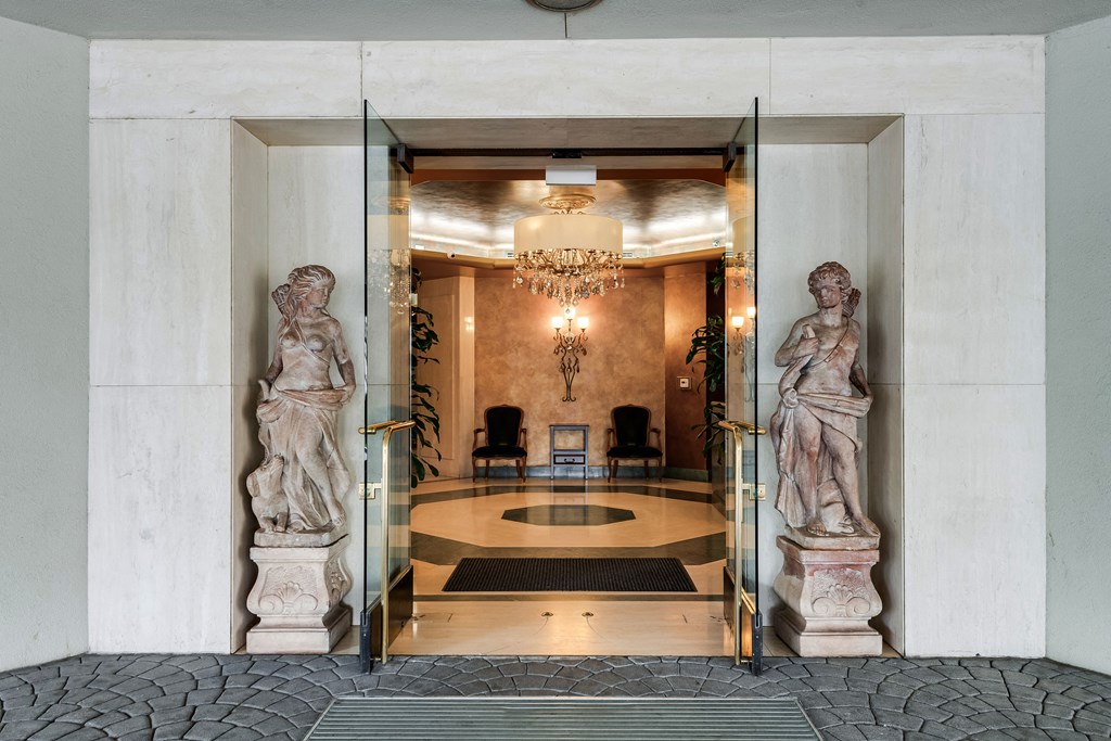 two statues in the lobby of a building with glass doors