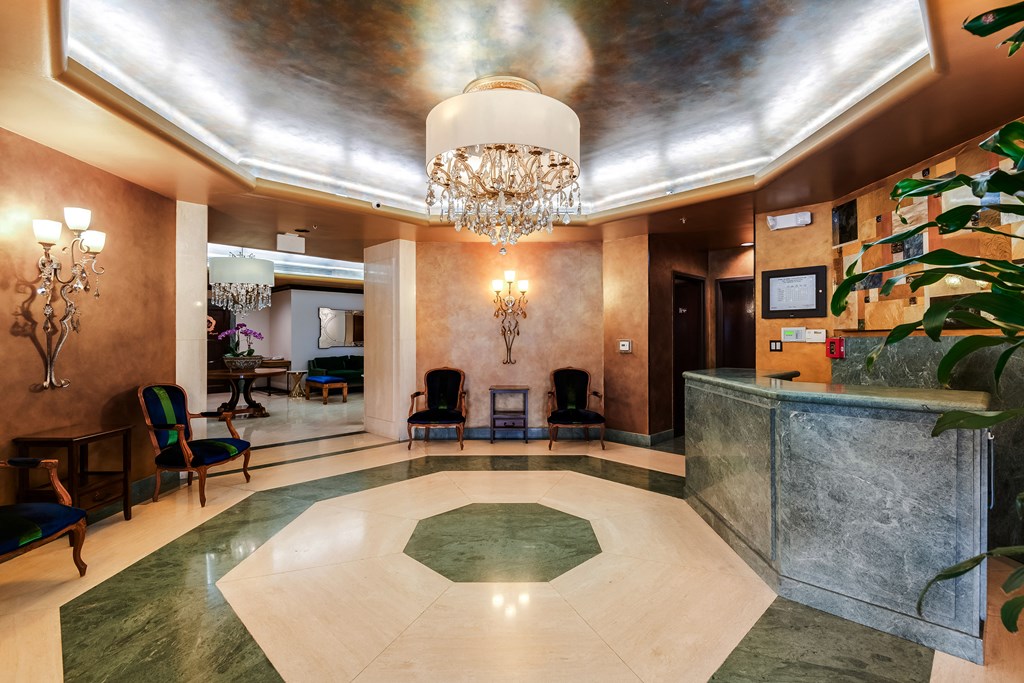 a lobby with a marble reception desk and a chandelier