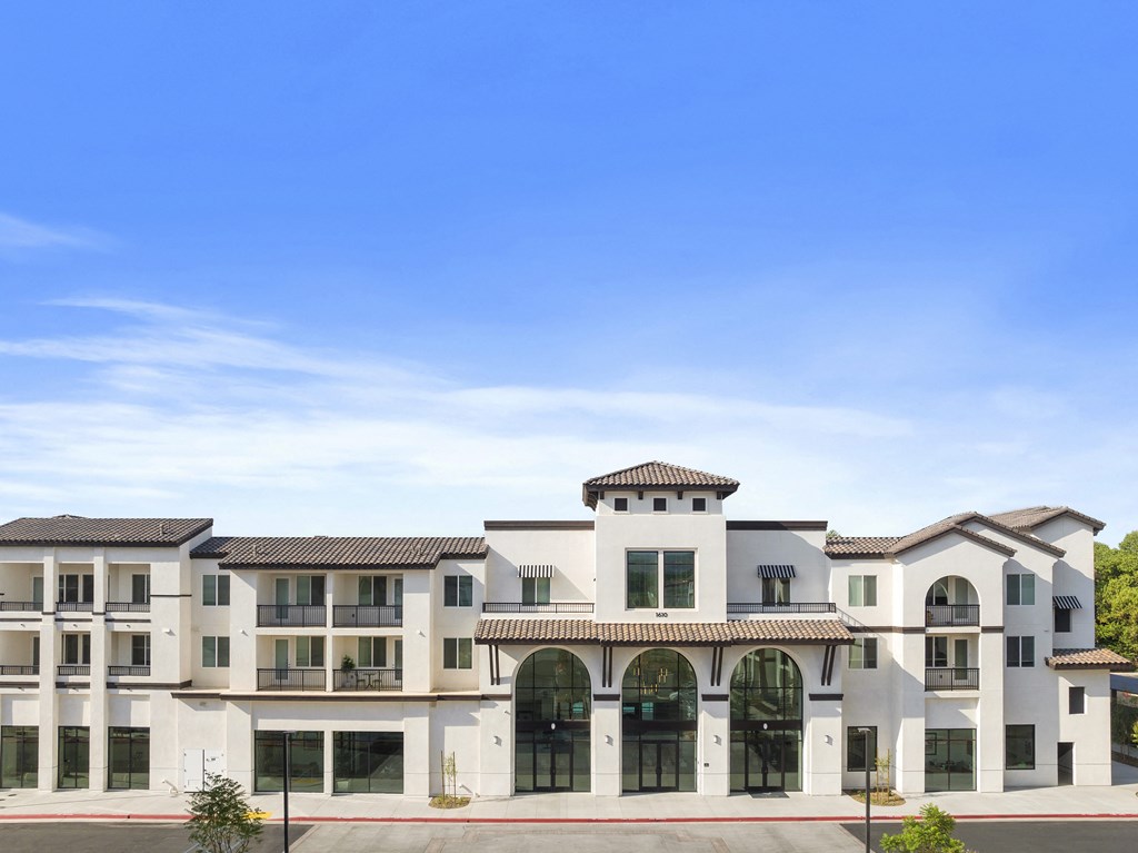 a large apartment building with a blue sky in the background at The Venue at Orange Apartments, Redlands, California