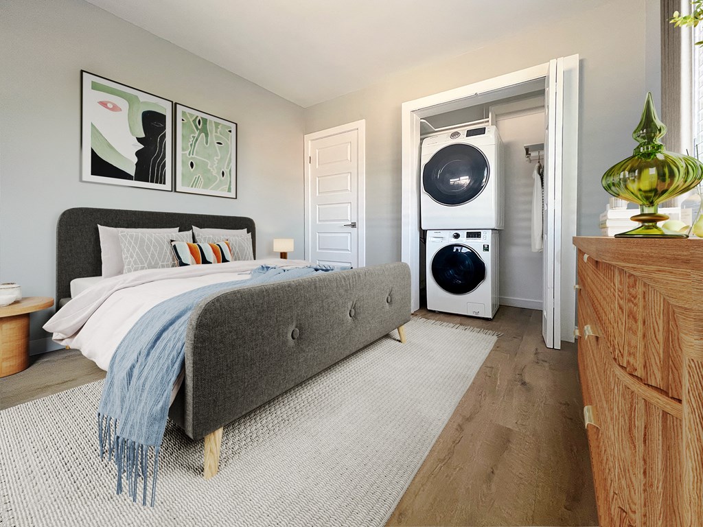 a bedroom with a bed and a washer and dryer