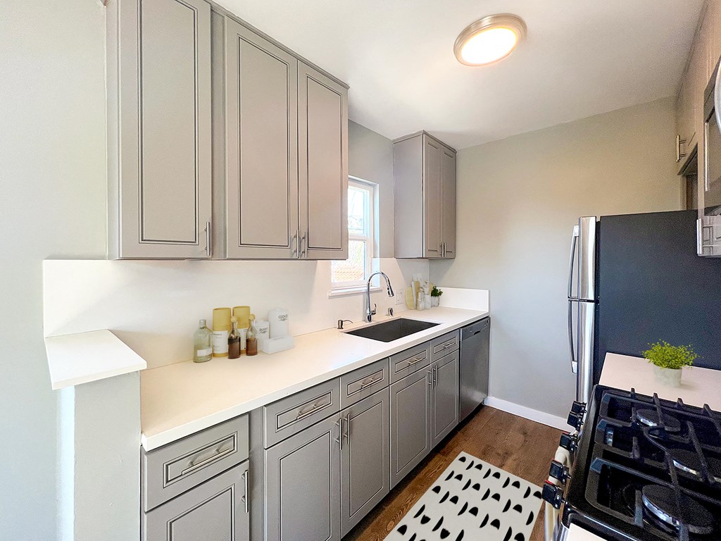 a kitchen with gray cabinets and a black refrigerator