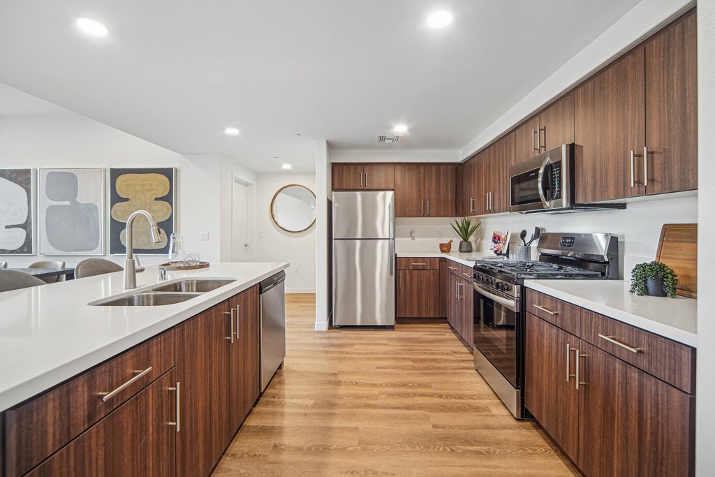 A modern kitchen with wooden cabinets and stainless steel appliances. at The Max on Jefferson Apartments, California, 92562