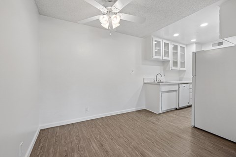 A kitchen with white cabinets and a ceiling fan.