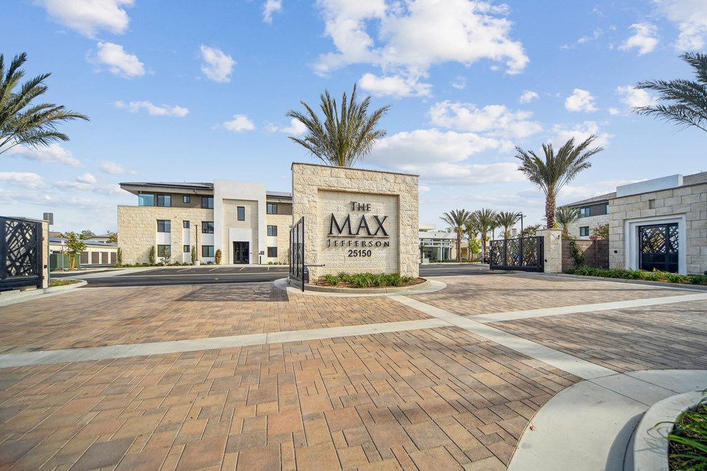The image shows a modern building with a sign that reads  at The Max on Jefferson Apartments, Murrieta, CA