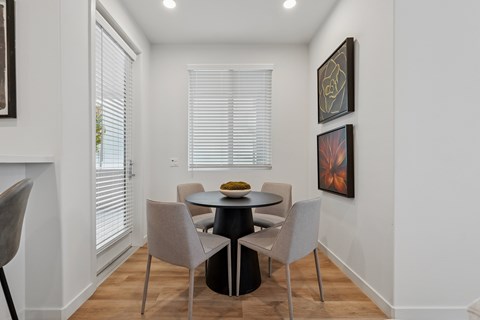 Dining nook with round table and upholstered chairs at The Park on Washington Apartments, Murrieta, California