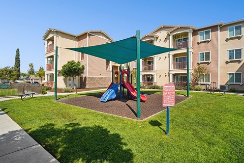 Play park at Turtle Creek under shade sail surrounded by park-like landscaping