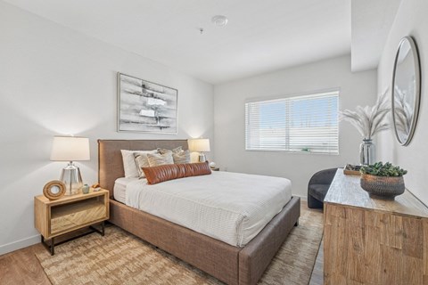 Bright bedroom with upholstered bed and modern furnishings at Altitude Apartments, Moreno Valley