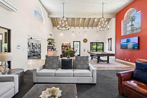 A living room with a grey couch and a brown leather chair.