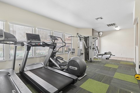 Fitness Center at California Place Apartments with plenty of equipment and large windows allowing for gorgeous natural lighting