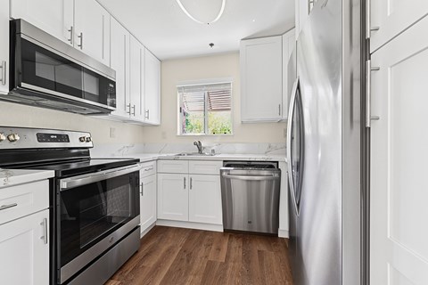 A kitchen with white cabinets and stainless steel appliances.