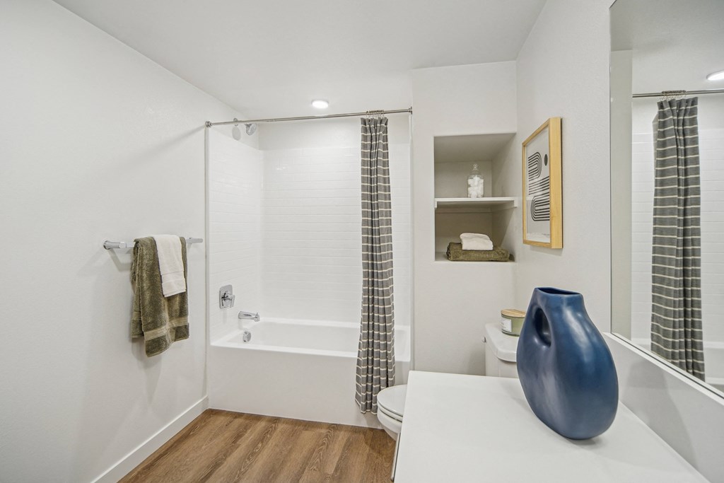 A white bathroom with a blue vase on the counter. at The Max on Jefferson Apartments, Murrieta
