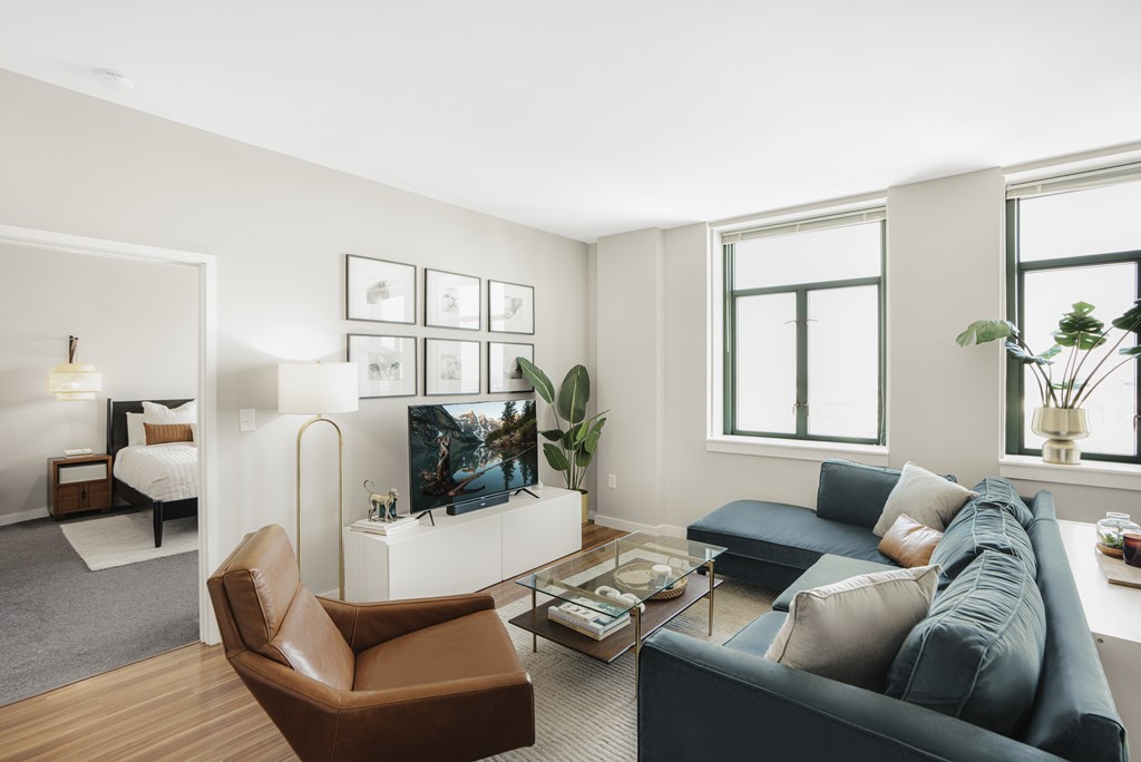 A living room with a brown leather chair and a blue couch.