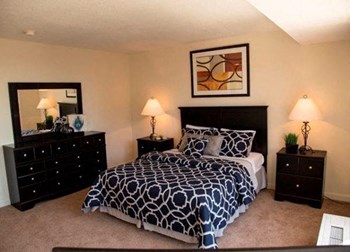 a bedroom with a bed and two night stands in a 1075 sq. ft. two bedroom apartment - Photo Gallery 16