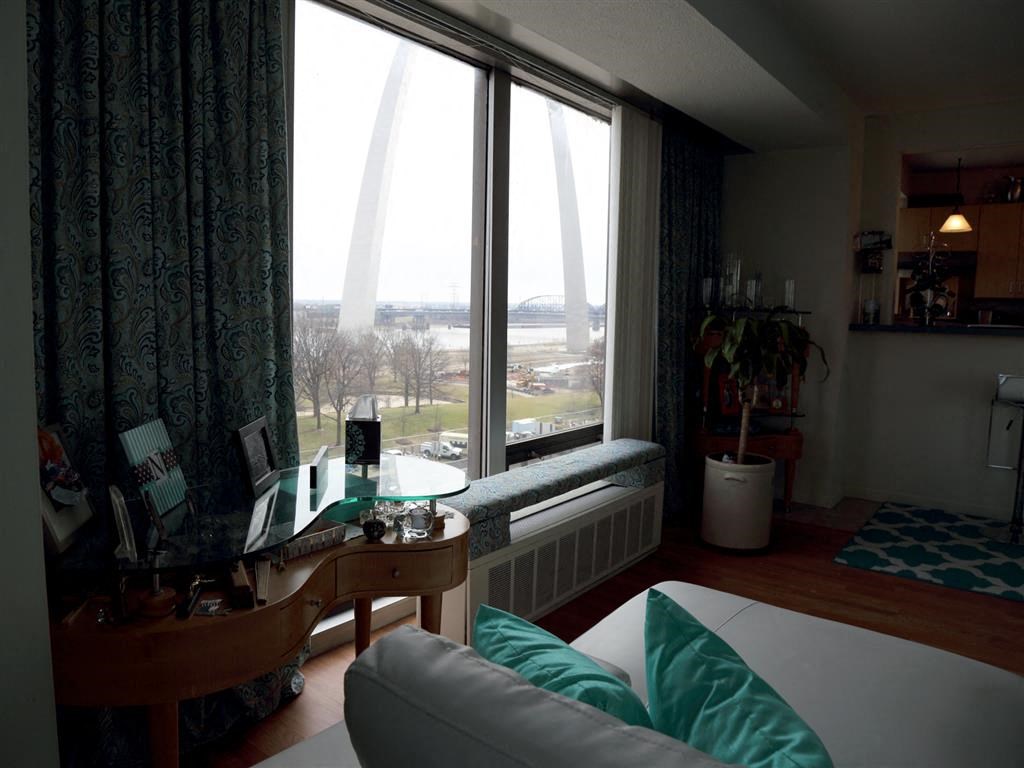 a living room filled with furniture and a large window overlooking the Gateway Arch monument