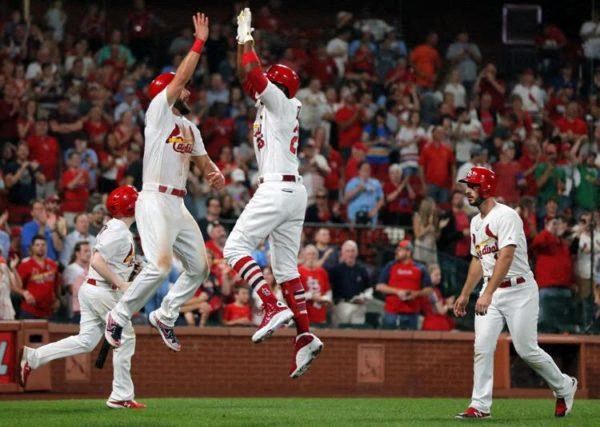 a group St. Louis Cardinal baseball players jumping in the air