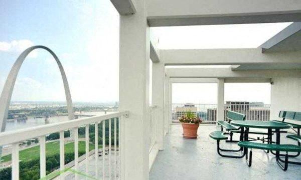 a balcony with a table and chairs and a arch in the background - Photo Gallery 1