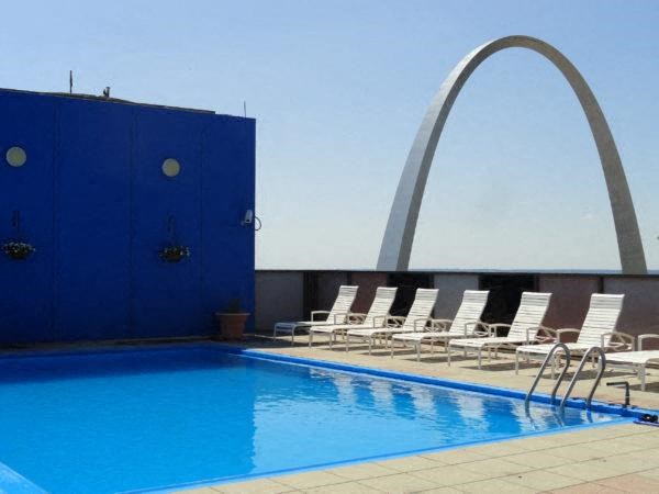 onsite rooftop swimming pool with chaise lounge chairs and the Gateway Arch in the background