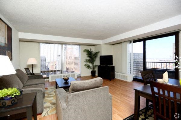 a living room filled with furniture and a flat screen tv in a 1075 sq. ft. two-bedroom apartment