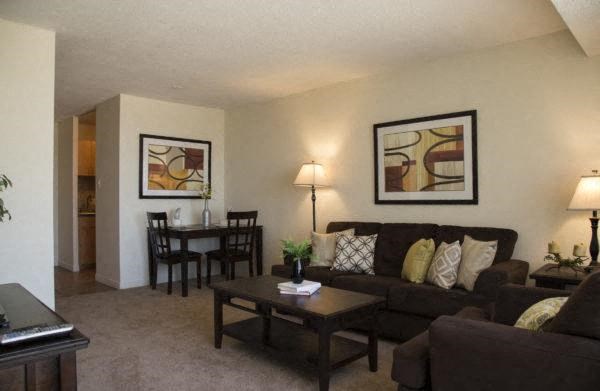 a living room with a couch table and chairs in a City view 1-bedroom apartment
