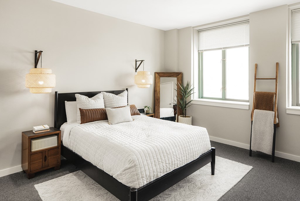 a bedroom with a bed and two windows