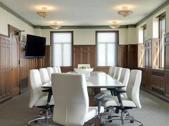 a conference room with a long table and white chairs