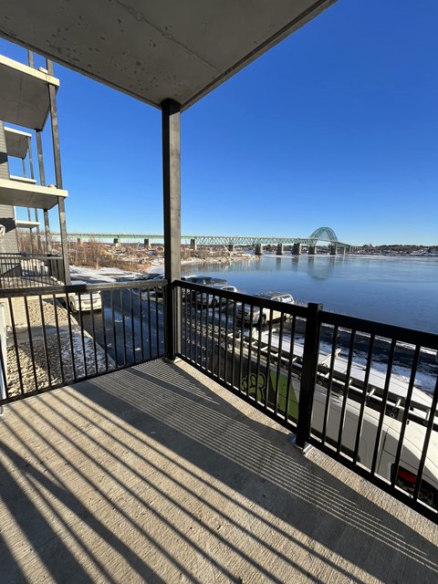 a balcony with a view of a river and a bridge