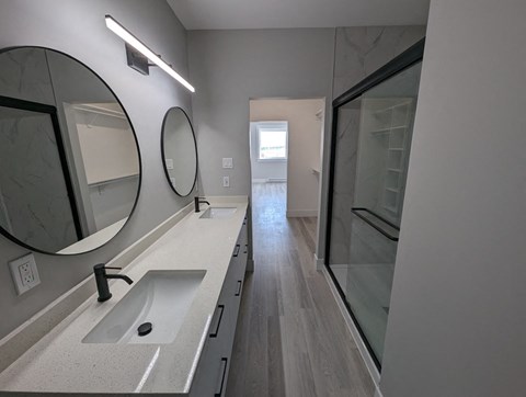 a bathroom with a sink and a mirror and a hallway