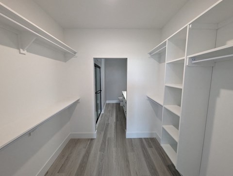 a room with white shelves and a white closet