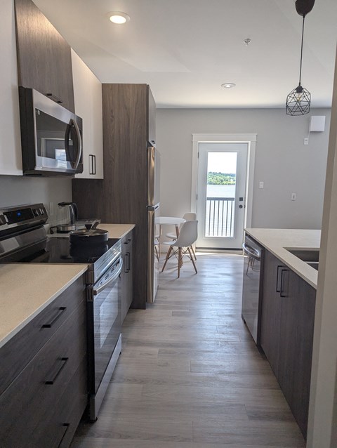 A kitchen with dark wood cabinets and a white counter.