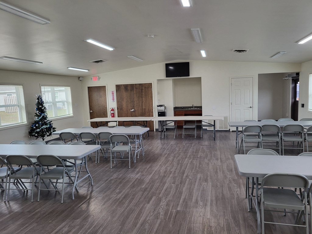 a conference room with tables and chairs and a christmas tree