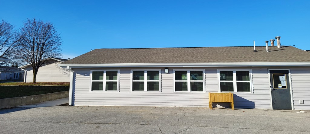 the front of a white building with a garage door