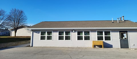 the front of a white building with a garage door