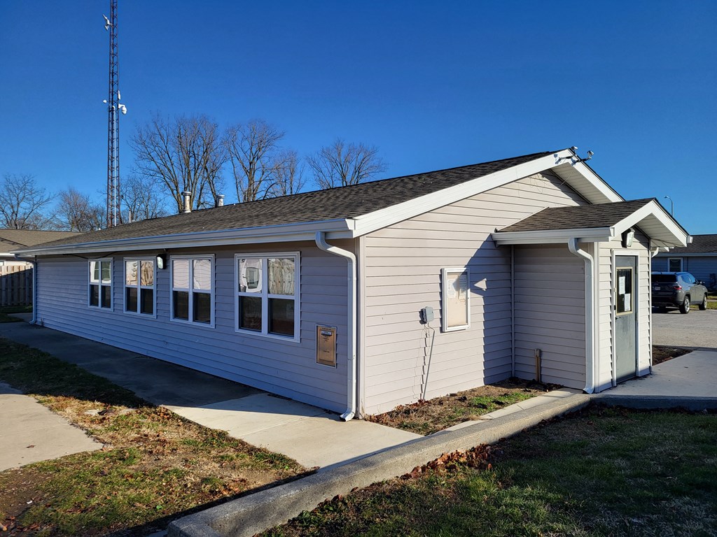 a small white house with a sidewalk in front of it