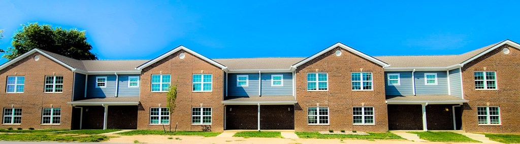 a large brick house with a blue sky in the background