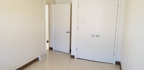 an empty hallway with white doors and white walls